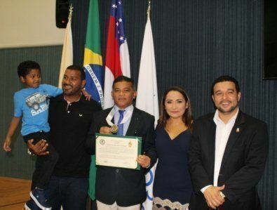 Professor Jorge Campos e família recebem homenagem das mãos de vereador Professor Fransuá (à direita).
